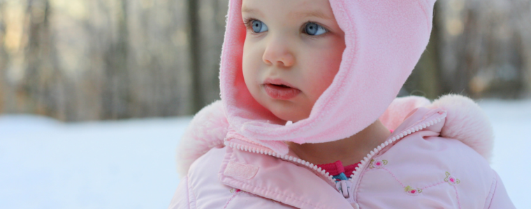 Bébé emmitouflé dans une combinaison chaude, un des indispensables pour l'hiver