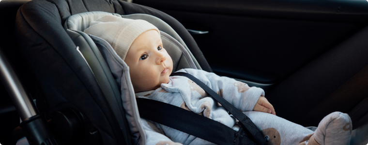 Voyage voiture bébé installé dans un siège auto