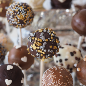 Sucettes au chocolat décorées avec des cœurs, des perles et des éclats dorés.