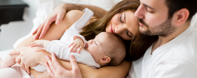 parents allongés avec leur bébé pour parler de la pma à leur enfant