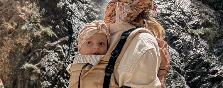 Maman portant son bébé en porte-bébé lors d'une randonnée — voyager avec bébé