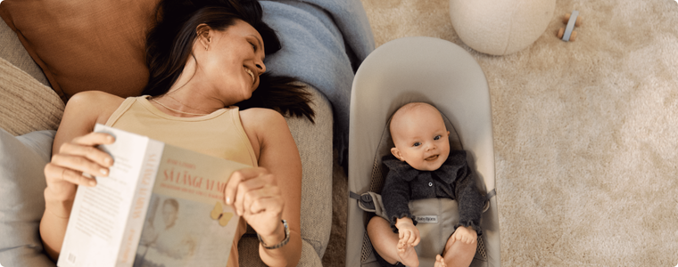 maman allongée à côté de son bébé dans un transat ergonomique