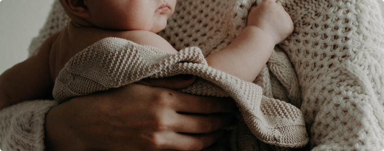 bain de bébé : bébé enveloppé dans une serviette, blotti contre son parent