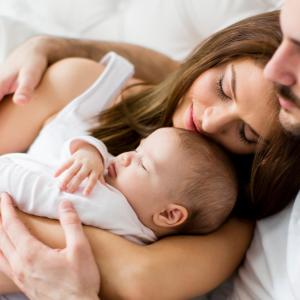 parents allongés avec leur bébé pour parler de la pma à leur enfant