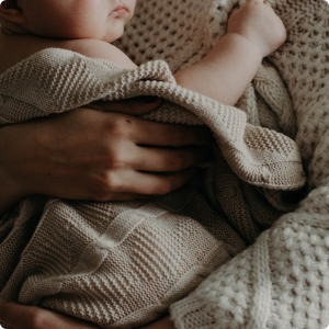 bain de bébé : bébé enveloppé dans une serviette, blotti contre son parent