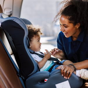 Maman souriant à son enfant installé dans un siège auto