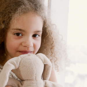 Un moment de tendresse entre une petite fille et son doudou préféré.