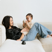 Maman et bébé sur le canapé ; stériliser le biberon pour une tétée sereine.