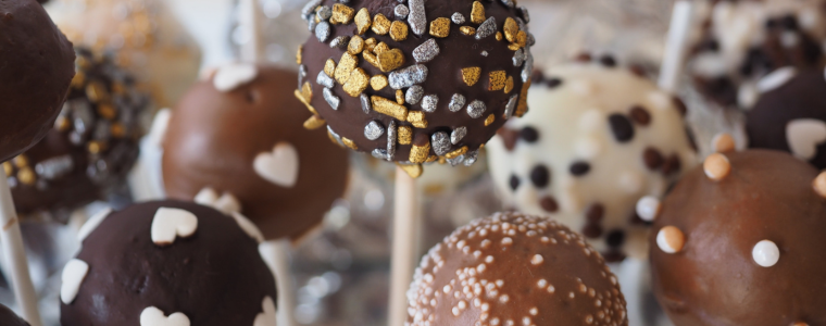 Sucettes au chocolat décorées avec des cœurs, des perles et des éclats dorés.